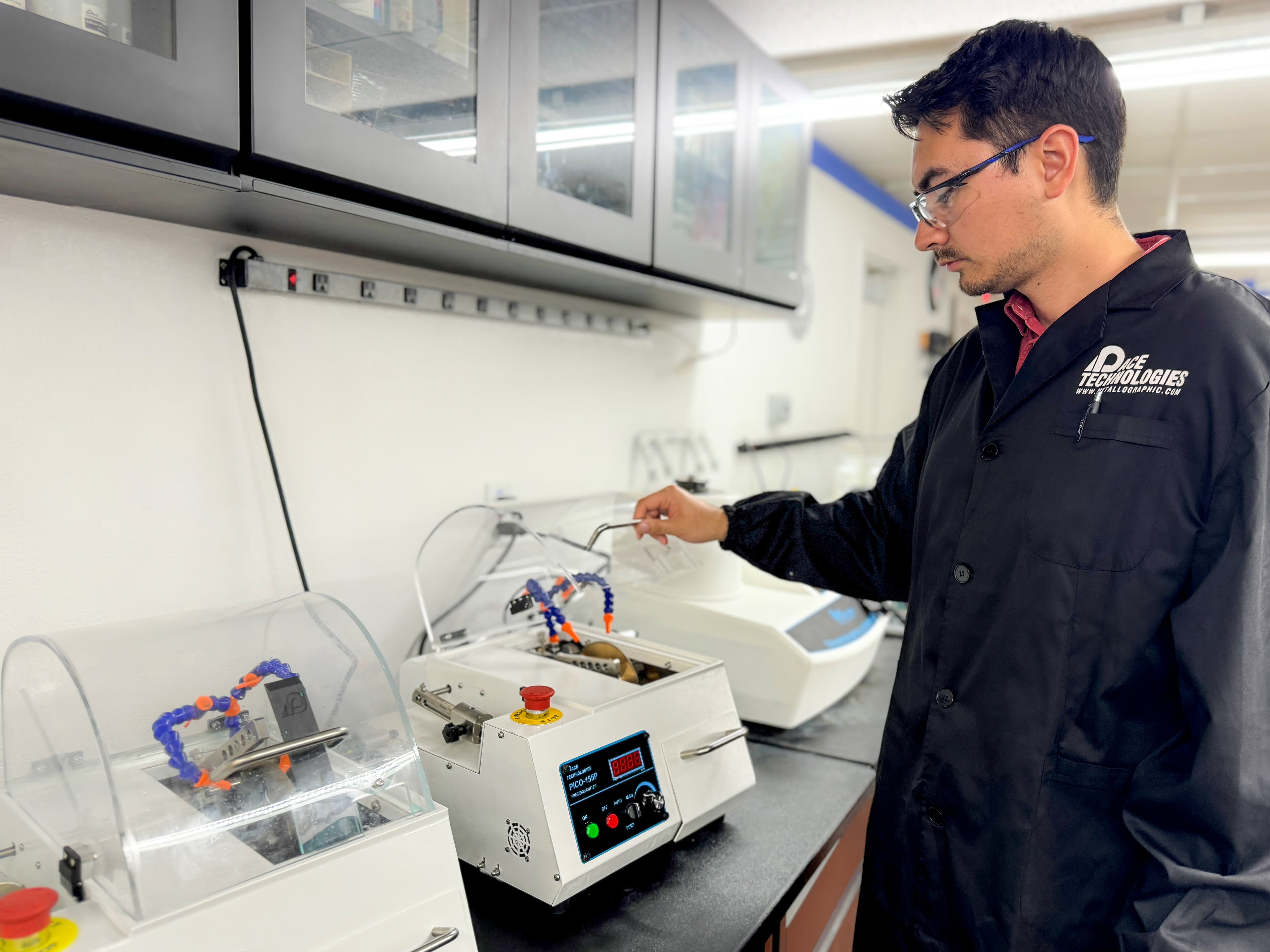 A PACE Technologies materials scientist operating a precision metallographic cutter in the lab.